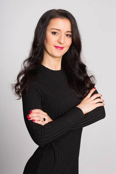 Beautiful brunette in black on a gray — Stock Photo, Image