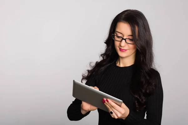 Jovem empresária feliz usando um computador tablet — Fotografia de Stock