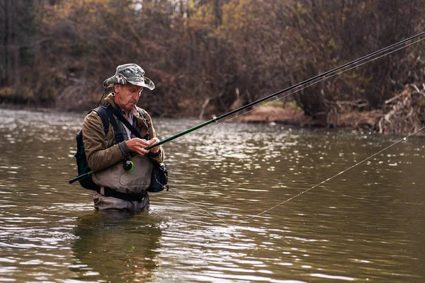 Pescador de pie en el río al pescar trucha —  Fotos de Stock