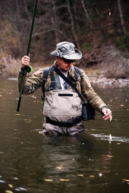 Balıkçı Gölge balığı yakaladı ve onu nehirden çeker