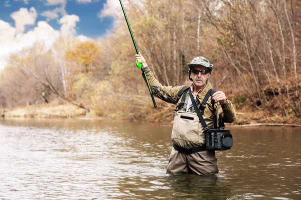 Pescador sosteniendo un grises atrapado en el río — Foto de Stock