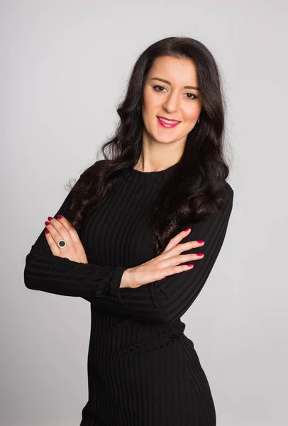 Woman with arms crossed against a background of gray wall — Stock Photo, Image