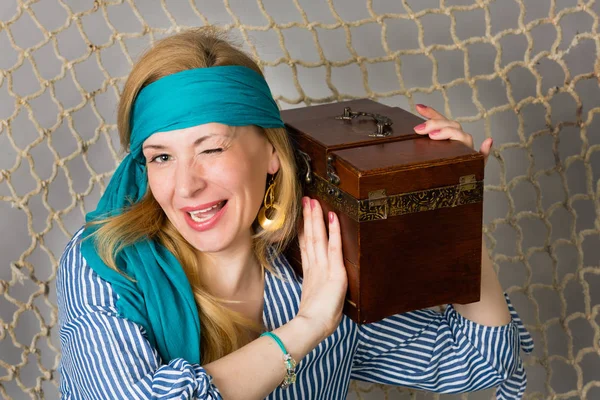 Beautiful woman holding a pirate with a chest — Stock Photo, Image