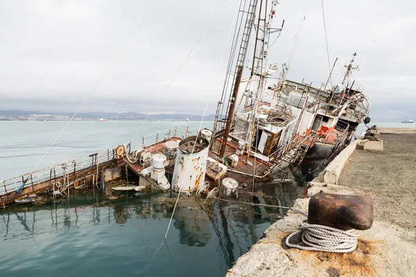 Un viejo barco pesquero hundido en un muelle en el puerto —  Fotos de Stock