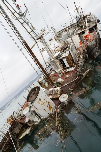 An old fishing boat sunk at a pier in seaport — Stock Photo, Image
