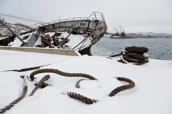 Corde d'amarrage repose sur une jetée avec navire coulé — Photo