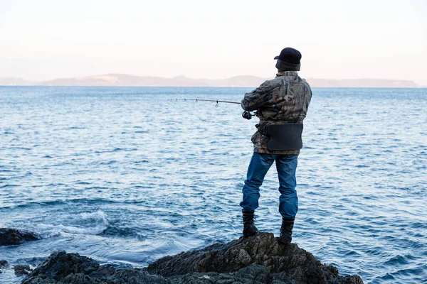 海によって岩に回転する漁師の魚 — ストック写真