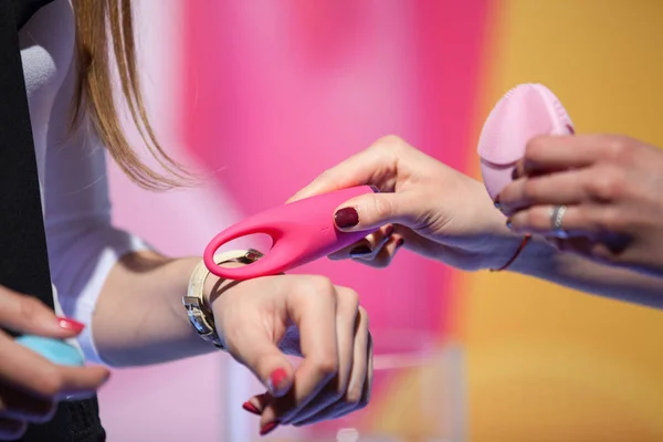 Las mujeres tratando de gadget de belleza en sus manos Imagen de archivo