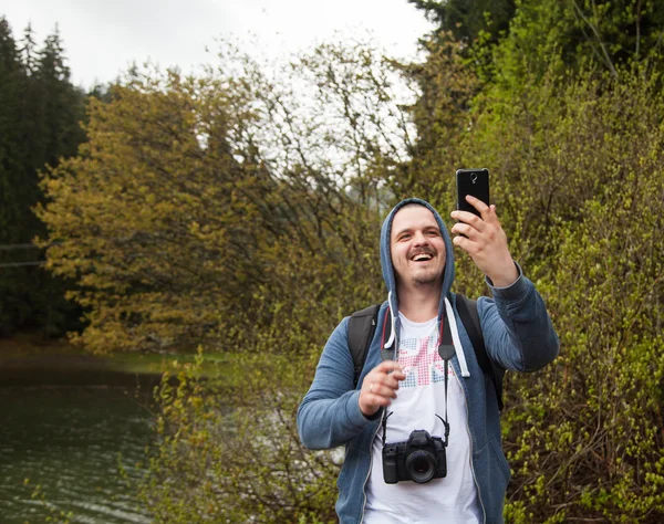 Uśmiechnięty mężczyzna trzyma jego smartphone — Zdjęcie stockowe