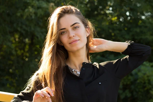 Mujer joven en el fondo de los árboles — Foto de Stock