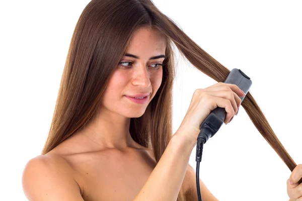 Жінка використовує випрямлення волосся — стокове фото