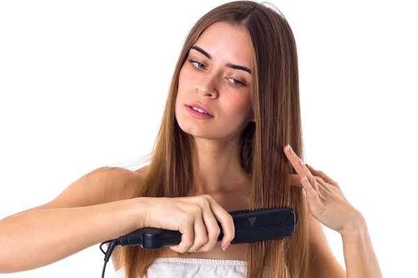 Woman using hair straightener — Stock Photo, Image
