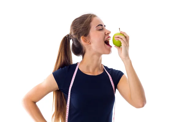 Женщина с сантиметром ест яблоко — стоковое фото
