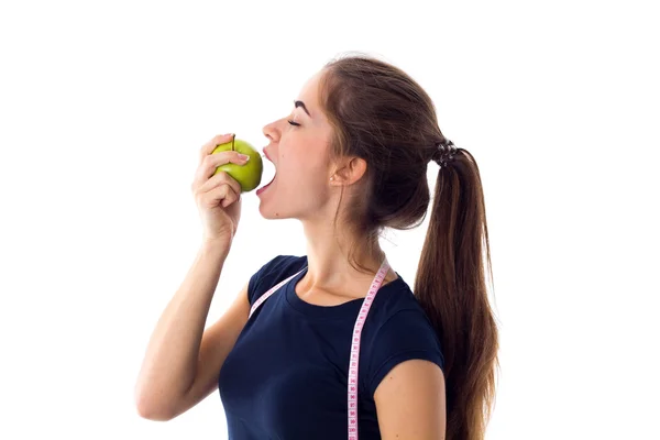 Mulher com centímetro comendo uma maçã — Fotografia de Stock