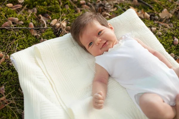 Bambino sdraiato sulla coperta sull'erba — Foto Stock