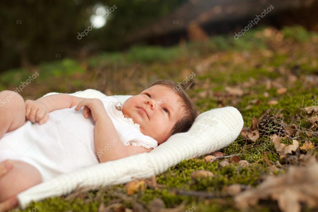 Baby lying on the blanket on the grass