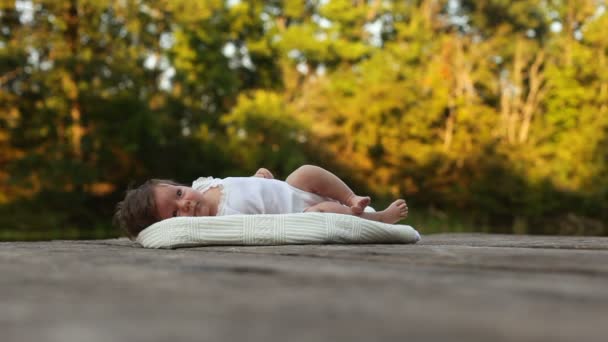 Bambino sdraiato sulla coperta nella foresta — Video Stock