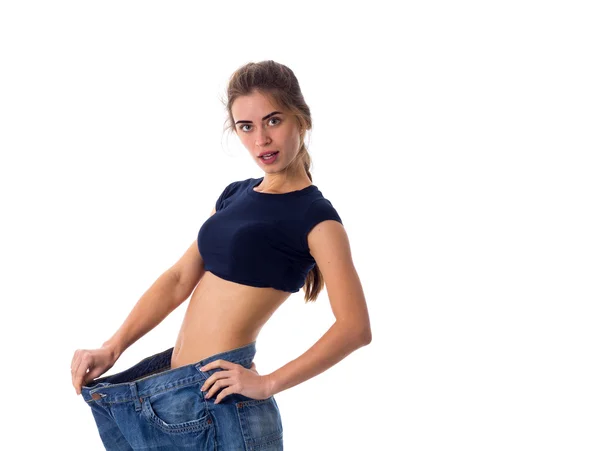 Woman wearing jeans of much bigger size — Stock Photo, Image