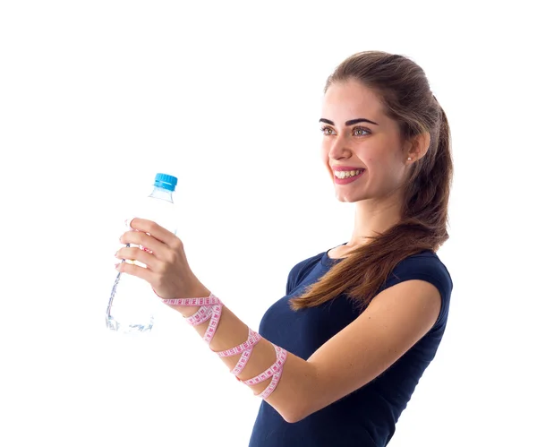 Woman with centimeter holding a bottle of water — Stock Photo, Image