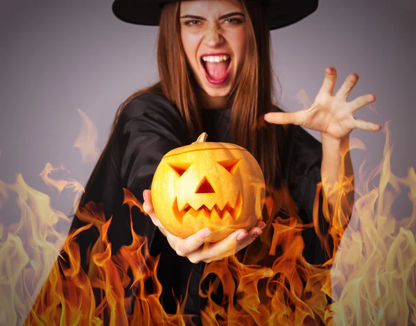 Nő a gazdaság egy tök tűz boszorkány jelmez — Stock Fotó