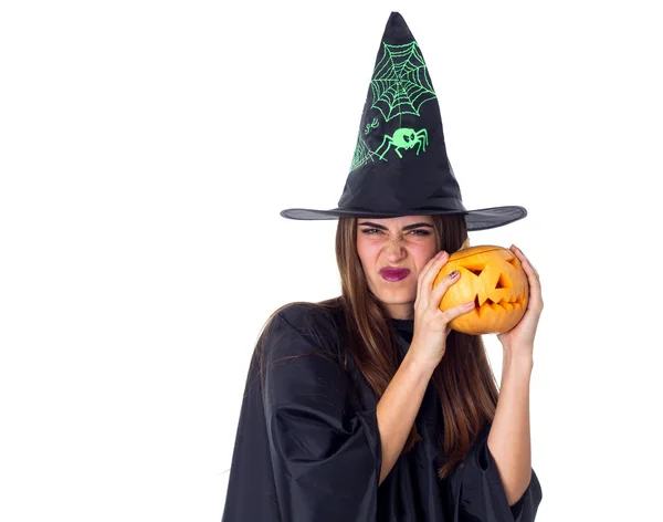 Mulher em traje de bruxa segurando uma abóbora — Fotografia de Stock