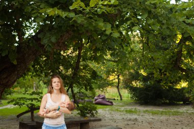 Uyuyan bebeği tutan genç kadın