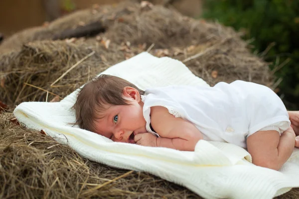 Bambino sdraiato sulla coperta sul fieno — Foto Stock