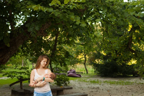 Young woman holding her sleeping baby — Stock Photo, Image