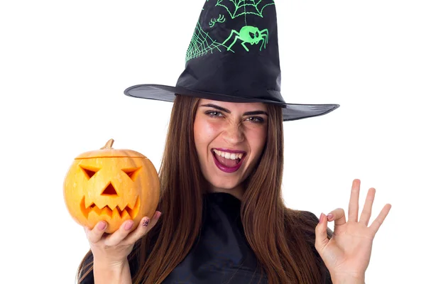 Femme en costume de sorcière tenant une citrouille et montrant OKAY — Photo