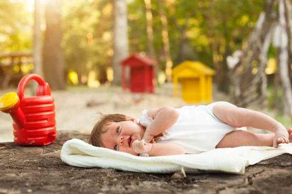 Bébé couché sur la couverture dans le parc — Photo