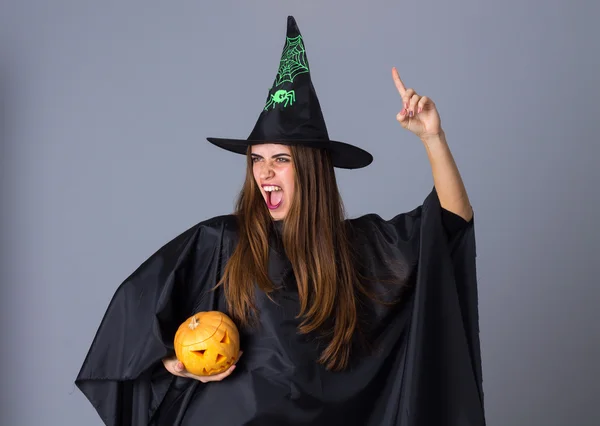 Femme en costume de sorcière tenant une citrouille — Photo