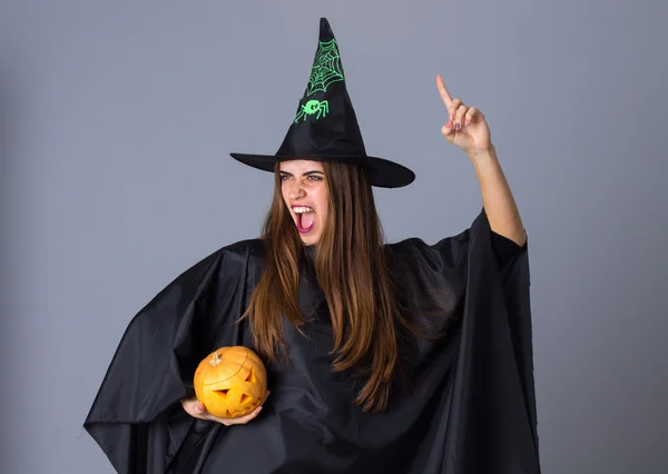 Mujer disfrazada de bruja sosteniendo una calabaza —  Fotos de Stock