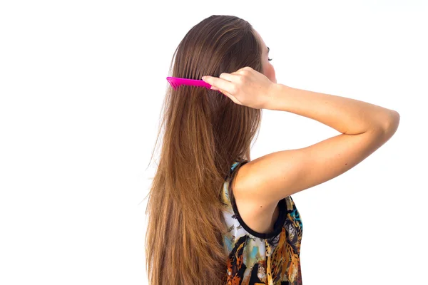 Jovem escovando seu cabelo comprido — Fotografia de Stock