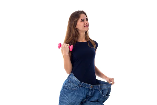 Жінка в джинсах набагато більшого розміру і тримає гантелі — стокове фото