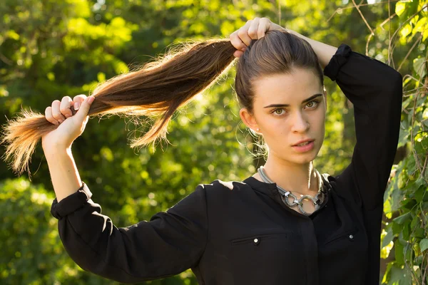 Mujer joven arreglando su cabello —  Fotos de Stock