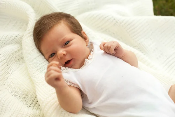 Baby liggend op de deken op het gras — Stockfoto