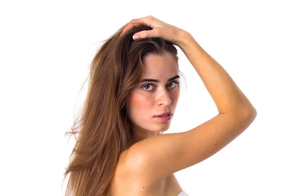 Женщина стоит сбоку и фиксирует волосы — стоковое фото