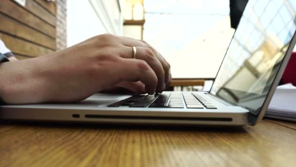 Молодий чоловік із золотим обручкою використовує свій ноутбук — стокове відео