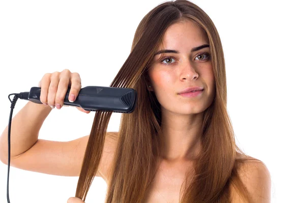 Жінка використовує випрямлення волосся — стокове фото