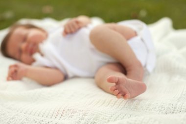 Çimenlerin üzerinde uyuyan bebek