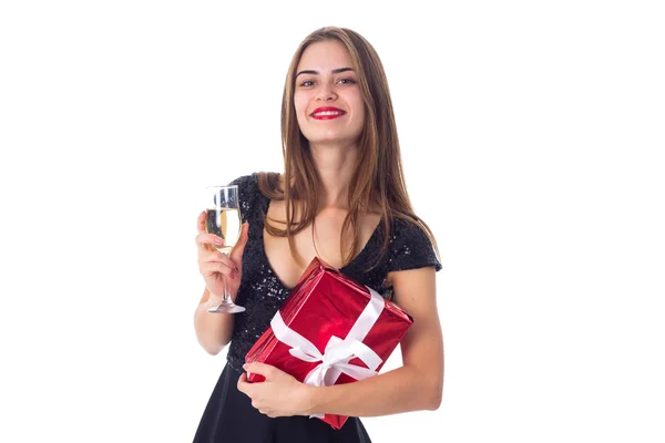 Bir hediye ve bir kadeh şampanya tutan genç kadın — Stok fotoğraf