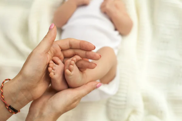 小さな赤ちゃんの足を持っている手 — ストック写真