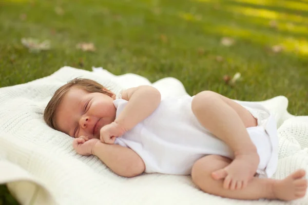 Bebê dormindo na grama — Fotografia de Stock