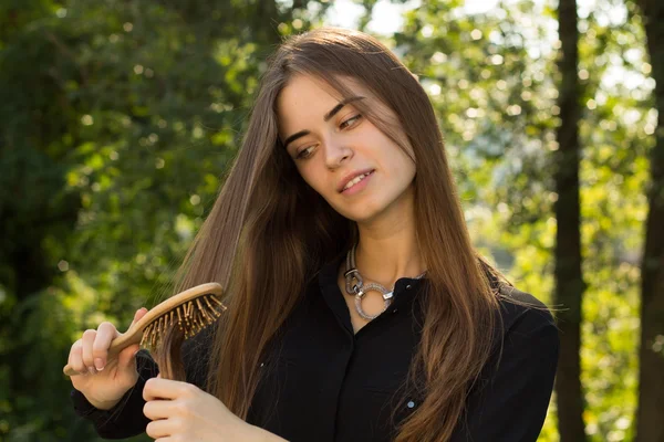 Mujer peinándose el pelo en el parque —  Fotos de Stock