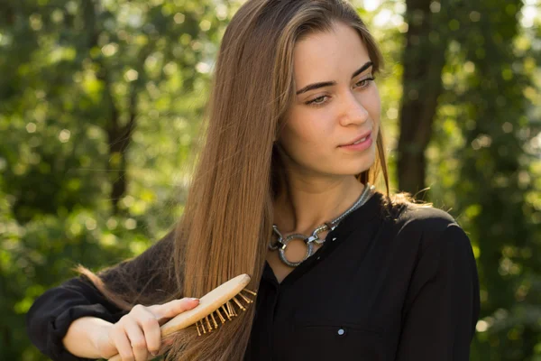 Женщина расчесывает волосы в парке — стоковое фото
