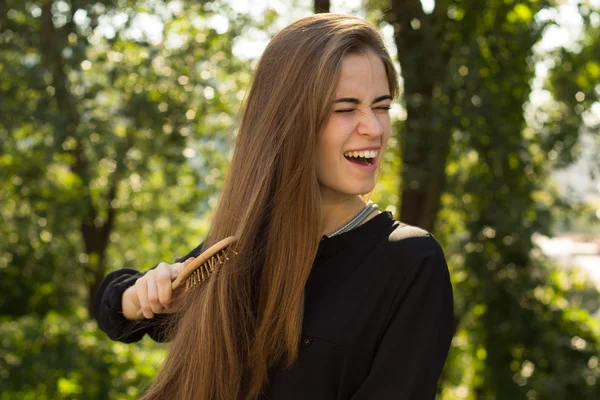 Mujer peinándose el pelo en el parque —  Fotos de Stock