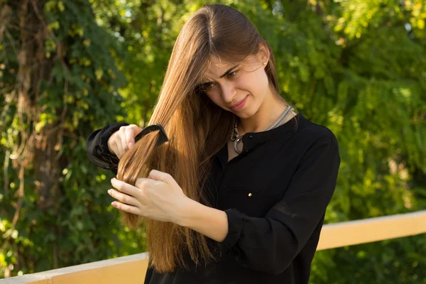 Kadın parkta onun saç tarama — Stok fotoğraf