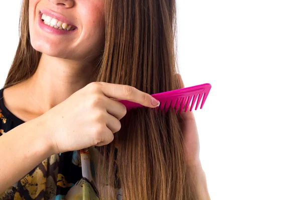 Mujer joven cepillándose el pelo largo — Foto de Stock