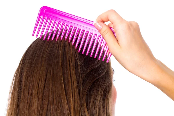 Mujer joven cepillándose el pelo largo — Foto de Stock