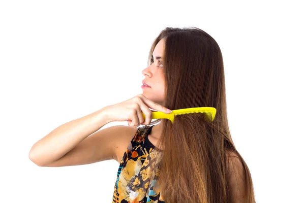 Jonge vrouw haar lange haren borstelen — Stockfoto